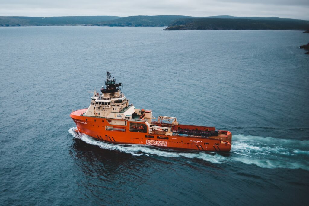 orange and white ship on sea during daytime